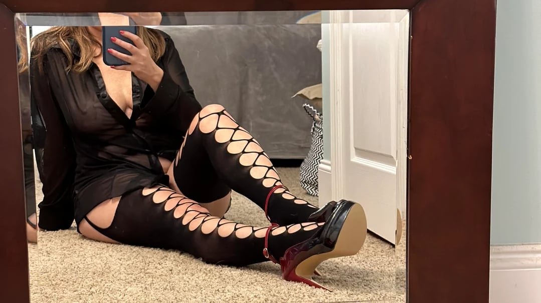 Femme mature sexy prenant un selfie devant son mirroir